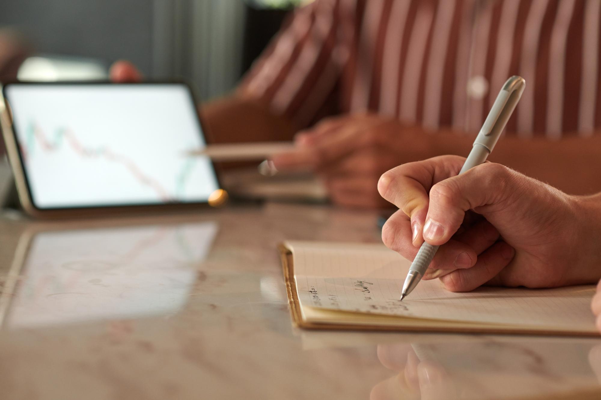 Nahaufnahme Hand mit Stift über Budgetplan